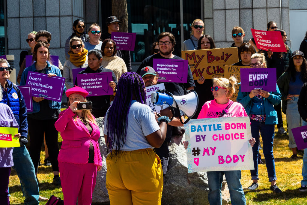 Protesters hold signs expressing their opinion during the...